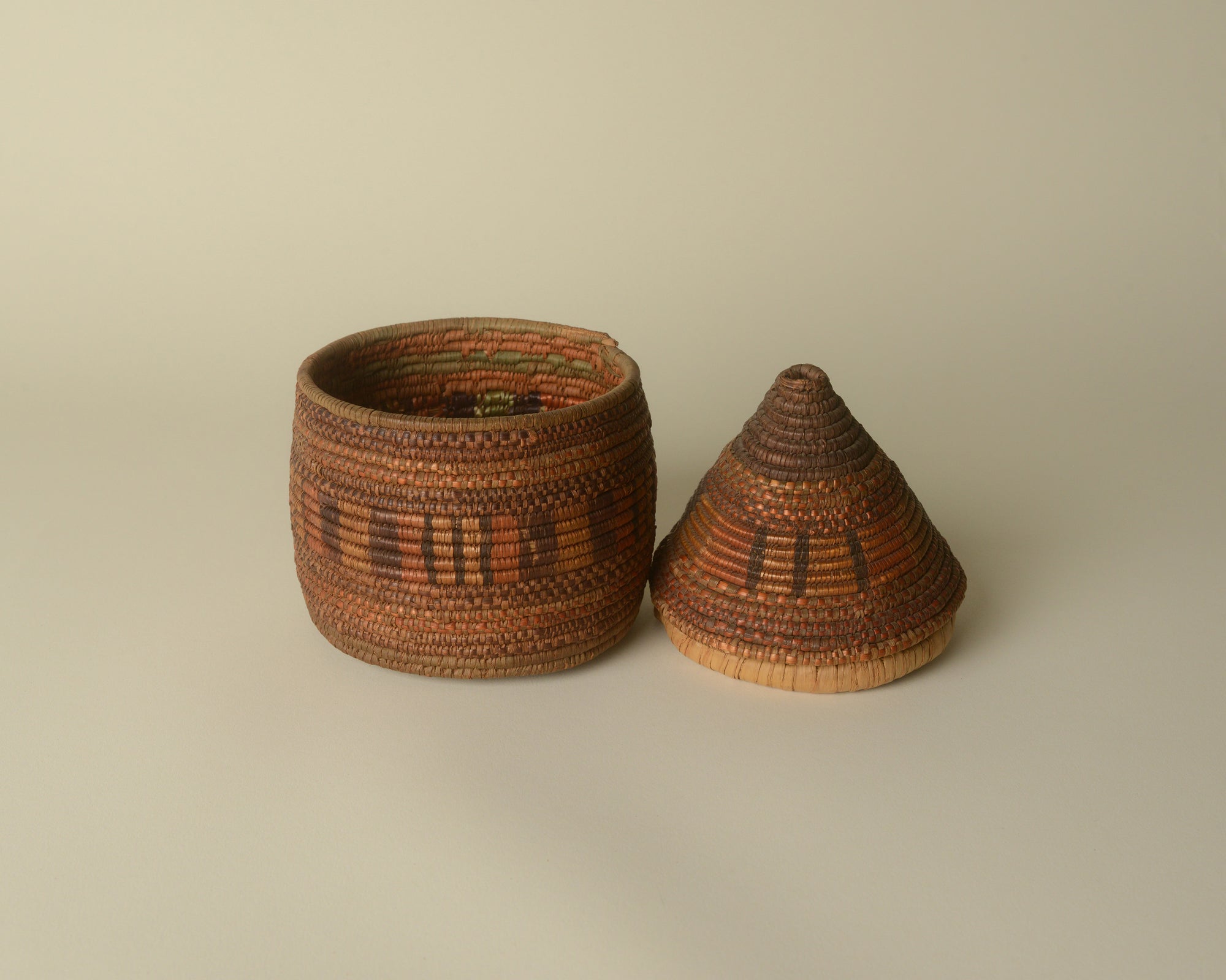 Small West African woven basket with pointy lid.